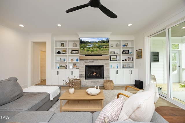 2200 Mays Crossroads Rd, Louisburg, NC 27549 - living area featuring light wood-type flooring, a stone fireplace, a ceiling fan, ornamental molding, and recessed lighting