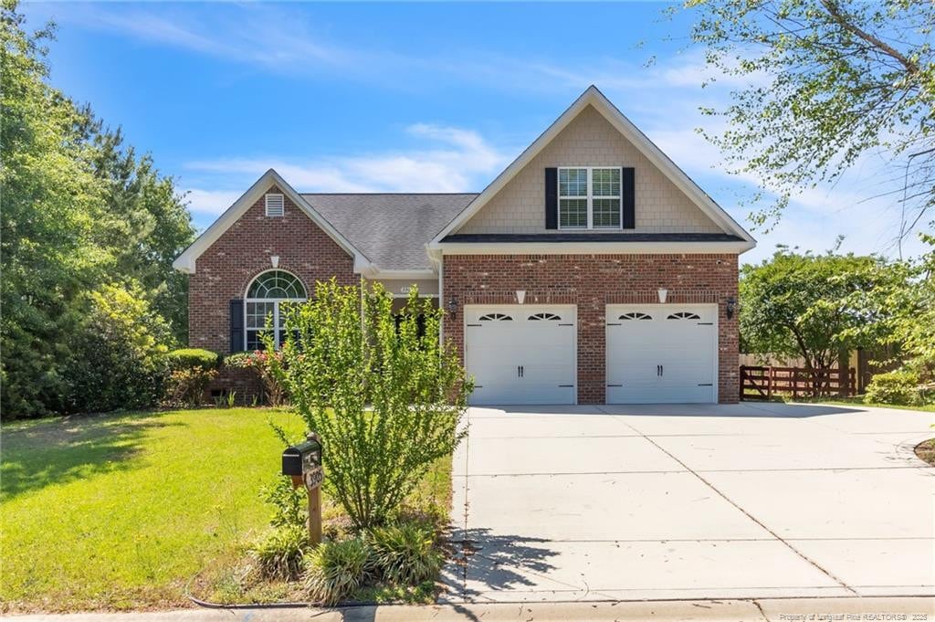 3905 Doon Valley Dr, Fayetteville, NC 28306 - traditional-style house featuring brick siding, driveway, and a garage