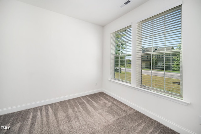 carpeted spare room featuring baseboards