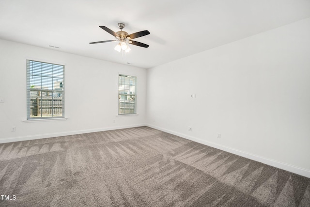 carpeted empty room featuring plenty of natural light, baseboards, and ceiling fan