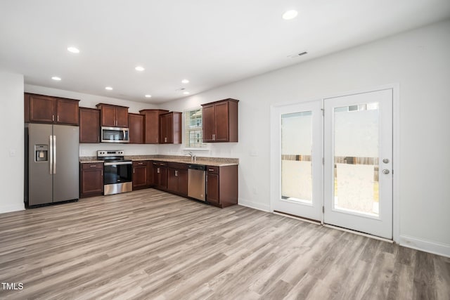 kitchen featuring appliances with stainless steel finishes, light wood-type flooring, recessed lighting, baseboards, and dark brown cabinetry