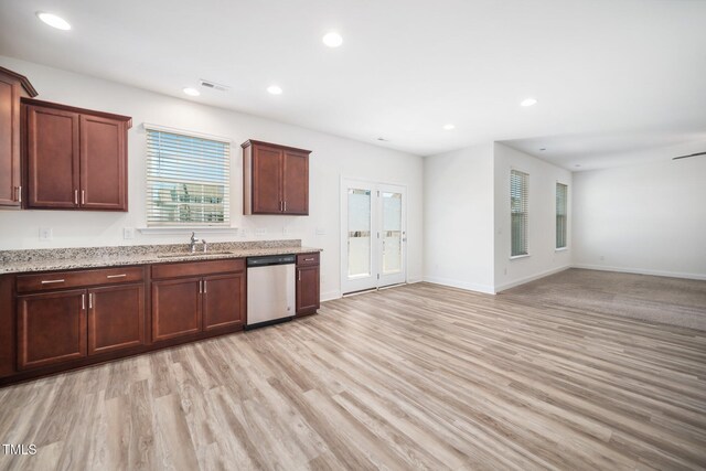 kitchen featuring stainless steel dishwasher, a sink, light wood-style flooring, recessed lighting, and light stone counters