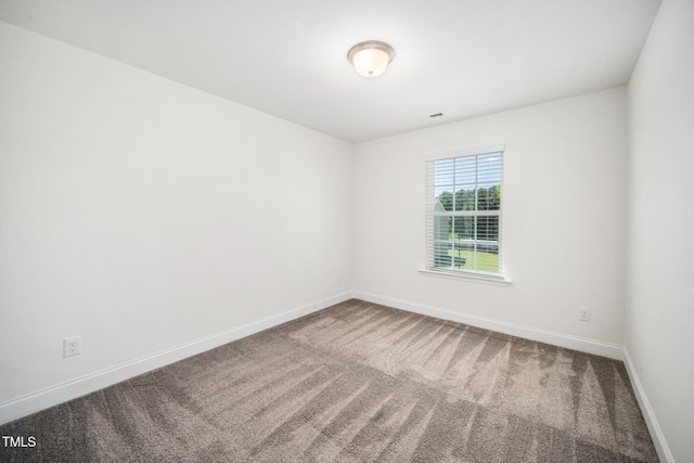 carpeted spare room featuring baseboards