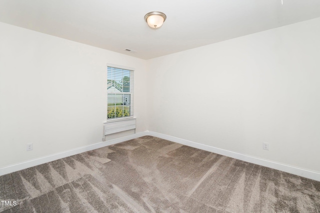 carpeted spare room featuring baseboards