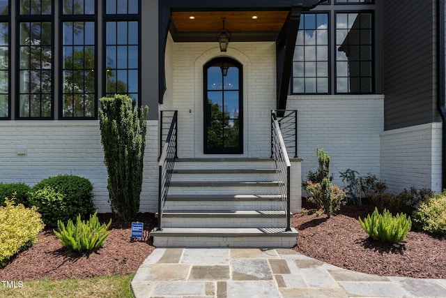 doorway to property with brick siding