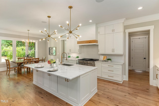 kitchen featuring a sink, a chandelier, ornamental molding, range with two ovens, and backsplash