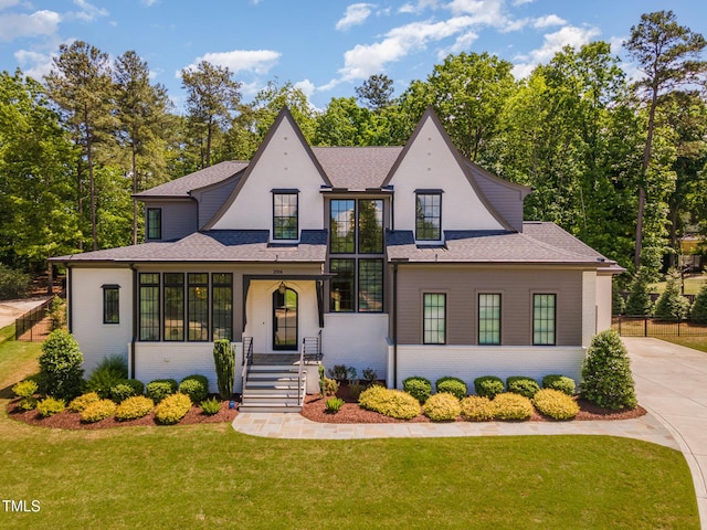 view of front of home featuring brick siding, a shingled roof, and concrete driveway