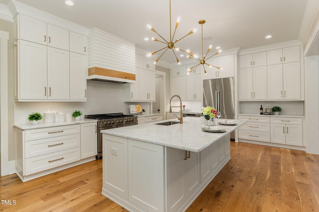 kitchen featuring high quality appliances, a sink, recessed lighting, a chandelier, and decorative backsplash