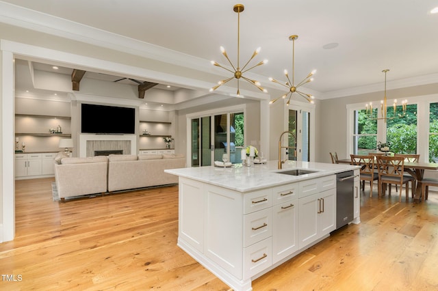 kitchen with a chandelier, a sink, crown molding, white cabinetry, and light wood-style floors