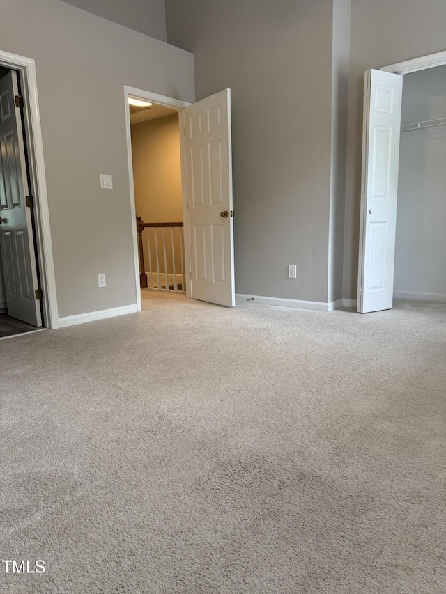 unfurnished bedroom featuring carpet flooring, baseboards, and a closet