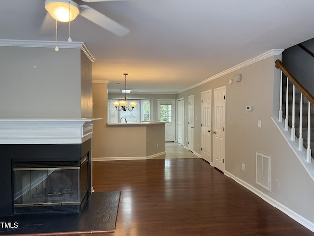 unfurnished living room featuring ornamental molding, stairs, baseboards, wood finished floors, and ceiling fan