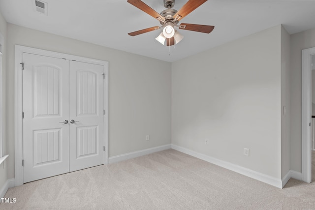 unfurnished bedroom featuring carpet, a closet, baseboards, and ceiling fan