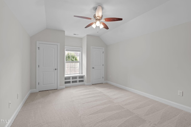 bonus room with vaulted ceiling, a ceiling fan, light carpet, and baseboards
