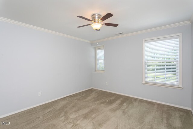 carpeted empty room featuring a ceiling fan, ornamental molding, and baseboards