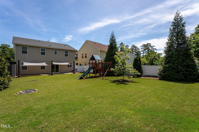 back of house with a playground and a fire pit