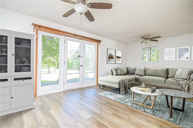 living area with ceiling fan, healthy amount of natural light, and light wood-style floors