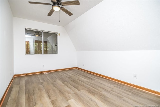additional living space featuring a ceiling fan, wood finished floors, baseboards, and lofted ceiling