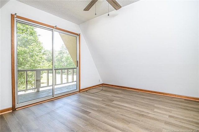 empty room featuring wood finished floors, ceiling fan, baseboards, and a textured ceiling