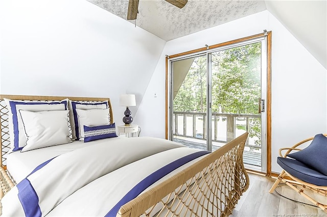 bedroom with access to outside, wood finished floors, vaulted ceiling, and ceiling fan