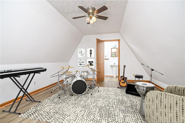 playroom featuring wood finished floors, baseboards, a ceiling fan, vaulted ceiling, and a sink