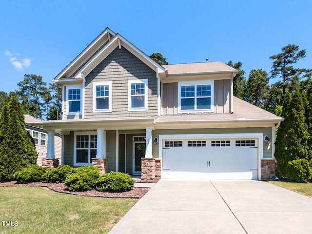 craftsman-style house featuring driveway, an attached garage, stone siding, board and batten siding, and a front yard