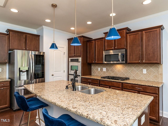 kitchen with stainless steel appliances, a sink, dark wood-style floors, a center island with sink, and a breakfast bar