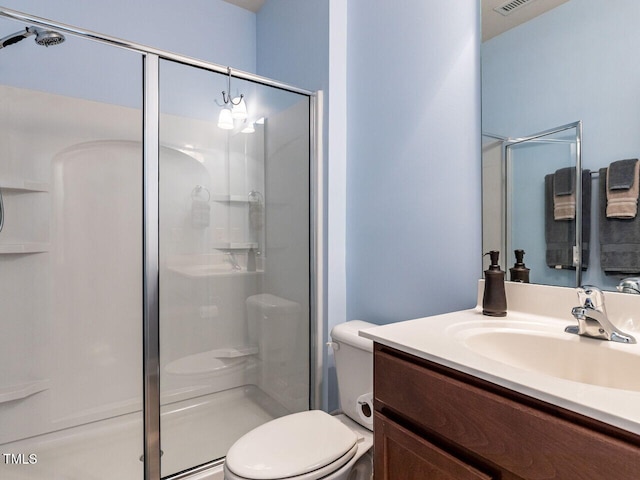 bathroom featuring a stall shower, toilet, and vanity