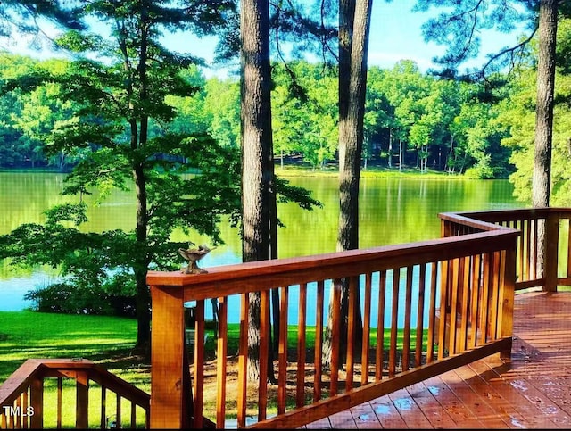 deck featuring a water view and view of wooded area