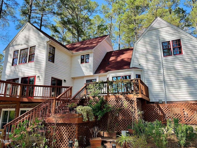rear view of property featuring stairway and a deck