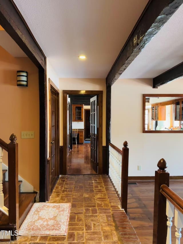 hall with baseboards, recessed lighting, brick patterned floors, and beamed ceiling