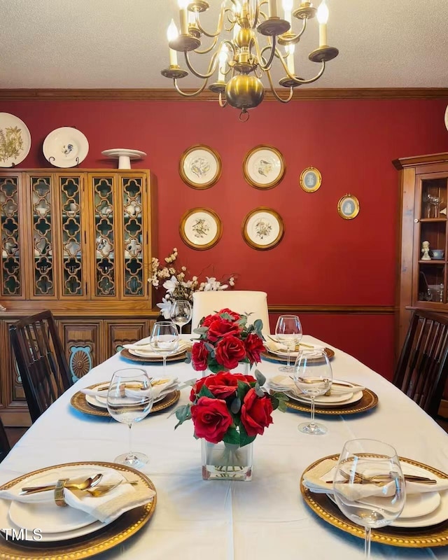 dining area featuring a chandelier, a textured ceiling, and crown molding