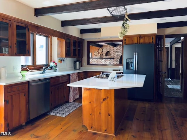kitchen with stainless steel appliances, light countertops, dark wood finished floors, a center island, and beam ceiling