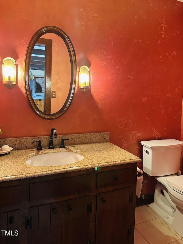 half bathroom with toilet, tile patterned flooring, and vanity