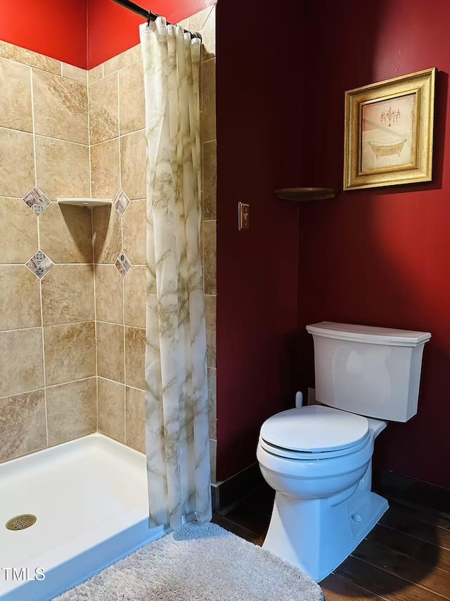full bath featuring a shower stall and toilet