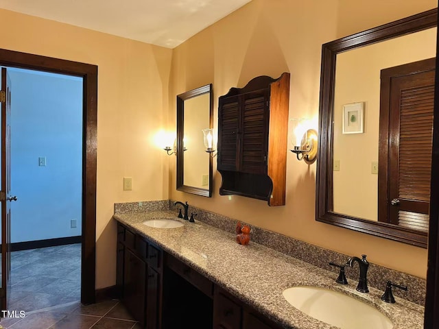 bathroom featuring double vanity, baseboards, and tile patterned flooring