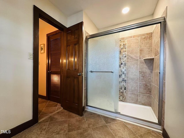 full bathroom featuring a stall shower, tile patterned floors, and baseboards