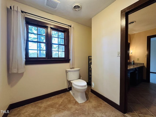 bathroom featuring baseboards, toilet, tile patterned flooring, and vanity