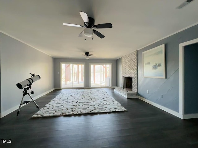 living room with baseboards, dark wood finished floors, ceiling fan, ornamental molding, and a brick fireplace