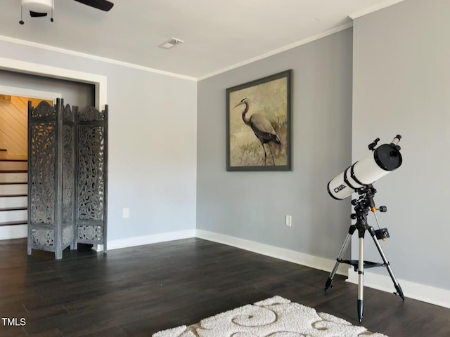 workout area with ornamental molding, wood finished floors, baseboards, and a ceiling fan