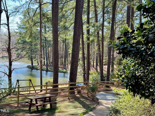 surrounding community featuring a water view and fence