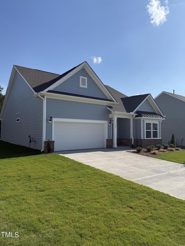 view of front facade featuring a garage, concrete driveway, a front lawn, and roof with shingles