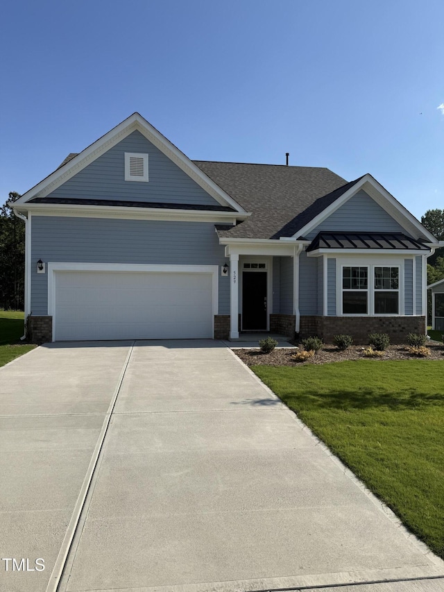 view of front of home with concrete driveway, brick siding, a front yard, and a garage
