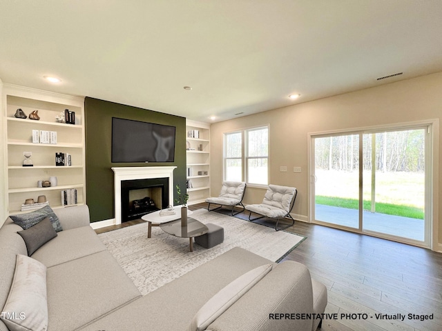 93 Butterbean Ct, Zebulon, NC 27597 - living area featuring wood finished floors, built in shelves, a fireplace, baseboards, and recessed lighting