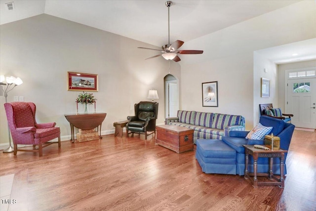 living room with lofted ceiling, light wood-type flooring, ceiling fan, and arched walkways