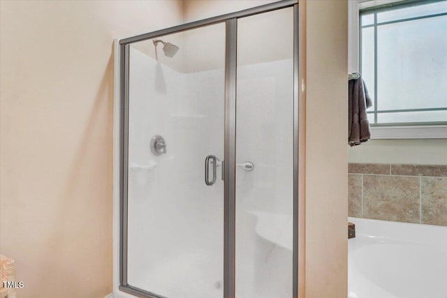 bathroom with a stall shower and a garden tub