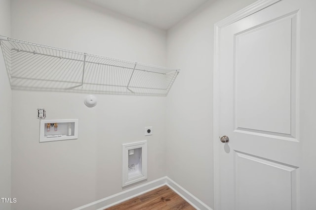 clothes washing area featuring hookup for an electric dryer, wood finished floors, washer hookup, baseboards, and hookup for a gas dryer