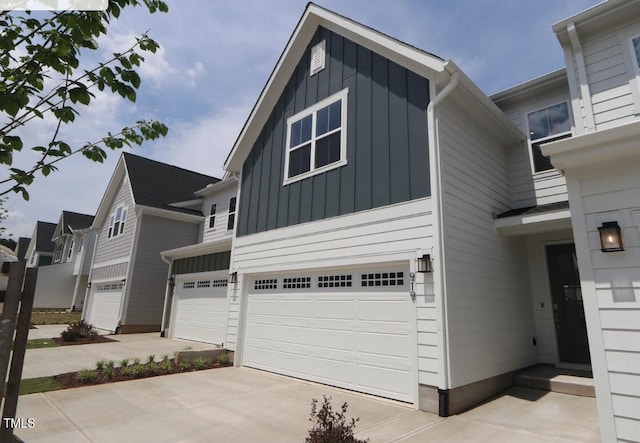 view of front facade featuring board and batten siding, an attached garage, and driveway