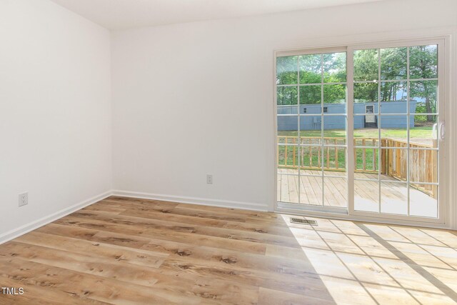 spare room featuring wood finished floors and baseboards