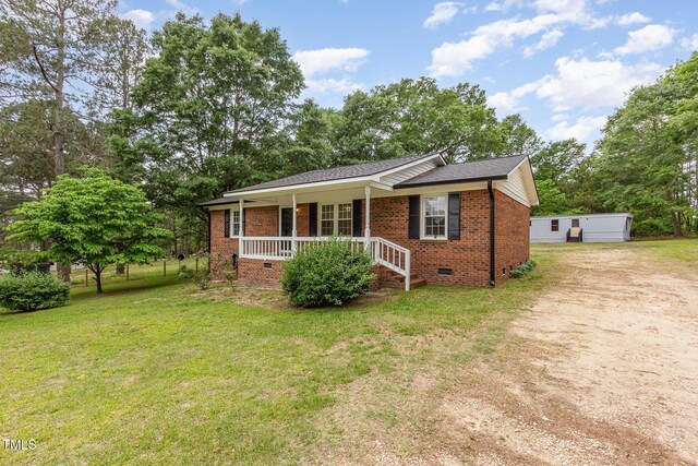 bungalow-style house featuring covered porch, brick siding, crawl space, driveway, and a front yard