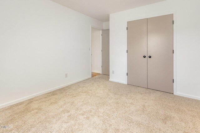 unfurnished bedroom with carpet flooring, baseboards, and a closet